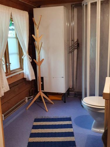 a bathroom with a toilet and a window at Nås Camping Dalarna, stuga nr 6 in Nås