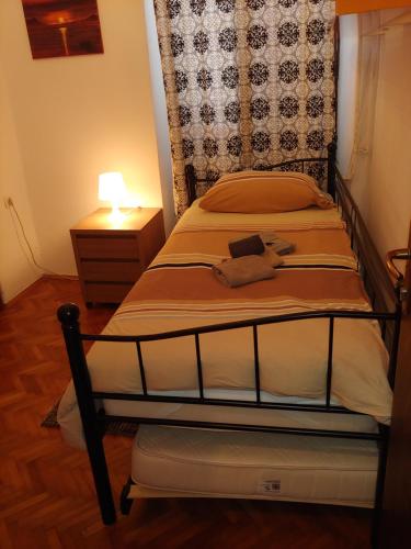 a bedroom with two beds and a night stand with a lamp at Sobe Al Moletto in Koper