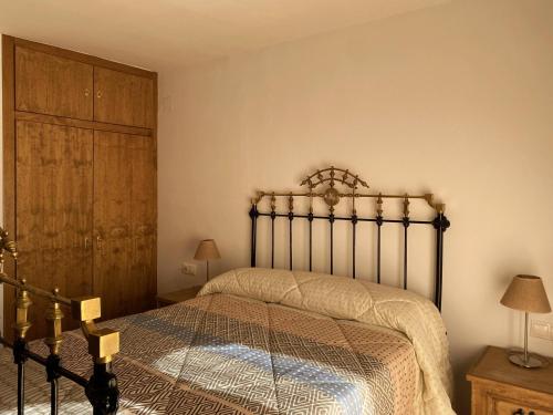 1 dormitorio con 1 cama y armario de madera en Casa Senagüilla, en Robledillo de Gata