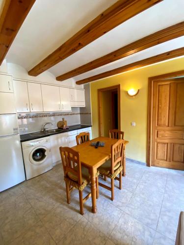a kitchen with a wooden table and chairs at Casa Campolé in San Juan de Plan