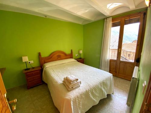 a green bedroom with a bed with two towels on it at Casa Campolé in San Juan de Plan