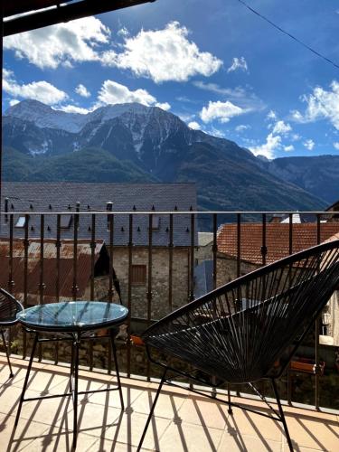 a chair and a table on a balcony with mountains at Casa Campolé in San Juan de Plan