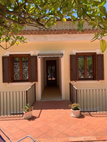 a house with two potted plants in front of it at Il Casalino in Maratea
