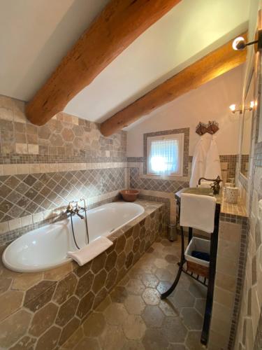 a bathroom with a large tub and a sink at Chambres d'hôtes et studios de charme - A Mandria in Murato