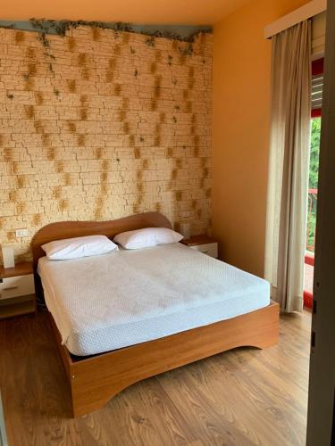 sypialnia z łóżkiem i ceglaną ścianą w obiekcie Casa Isabella w mieście Madonna del Sasso