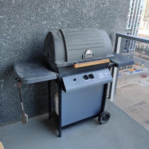 a grill sitting on a cart next to a wall at Monki Di Executive Suites - Alura in Calgary