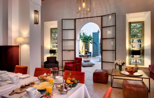 una sala da pranzo con tavolo, sedie e specchio di Riad Antara a Marrakech