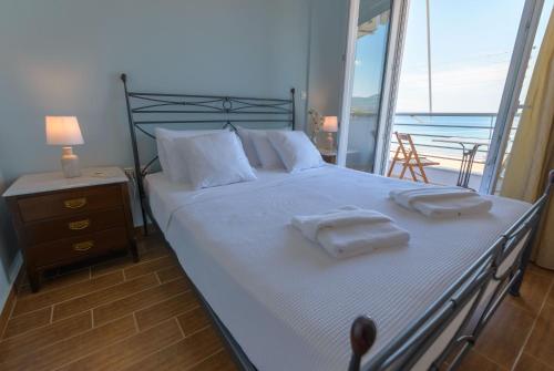- une chambre avec un lit et des serviettes dans l'établissement Lemoni Luxury Residence in front of the Sea, à Kekhriaí