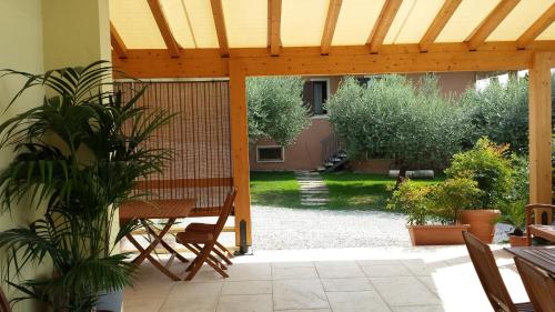 a patio with a table and a wooden pergola at Agriturismo La Palazzina in Castelnuovo del Garda