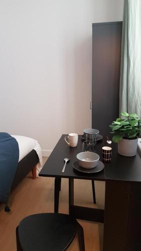 - une table noire avec un bol dans la chambre dans l'établissement Suite dans l'hyper-centre de Rueil Malmaison, La Défense à 15 minutes, à Rueil-Malmaison