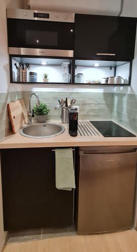 une cuisine avec un évier et un plan de travail dans l'établissement Suite dans l'hyper-centre de Rueil Malmaison, La Défense à 15 minutes, à Rueil-Malmaison