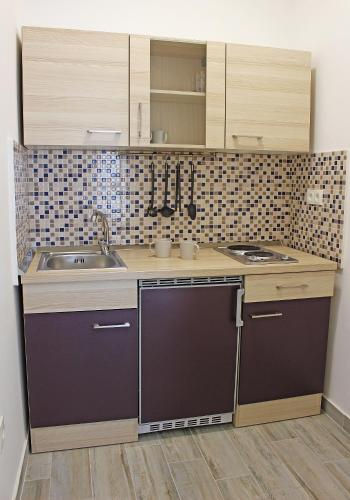a small kitchen with a sink and a stove at Apartmani Bodo in Drvenik