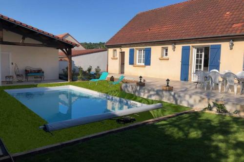 une cour arrière avec une piscine et une maison dans l'établissement Maison privative 5 Ch. 12 Pers. Piscine chauffée, à Désertines
