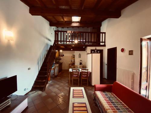 un soggiorno con divano rosso e una scala di Casa al Vittoriale degli Italiani di Gabriele D' Annunzio - Casa Vacanze a Gardone Riviera
