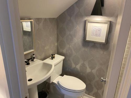 a small bathroom with a toilet and a sink at The Cornell Inn, Lenox & The Berkshires in Lenox