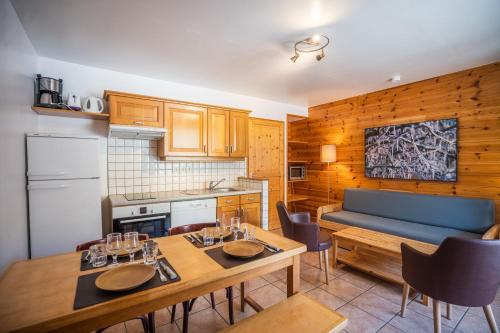 una cocina con 2 mesas y un sofá azul en Cellier 4, en Les Deux Alpes