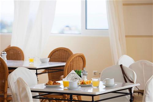 a dining room with tables and chairs with food on them at Kastalia Village ,Saint Nikolas resort in Kolymvari