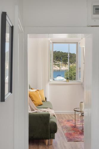 a living room with a green couch and a window at Apartman Rakic in Makarska