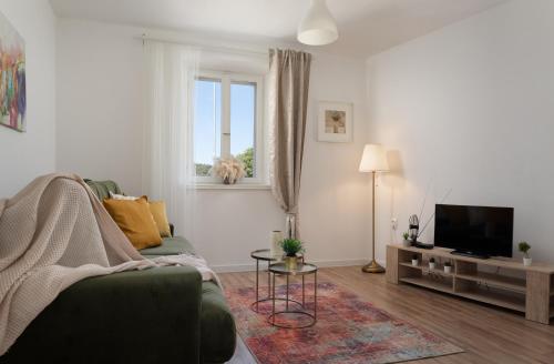 a living room with a green couch and a television at Apartman Rakic in Makarska