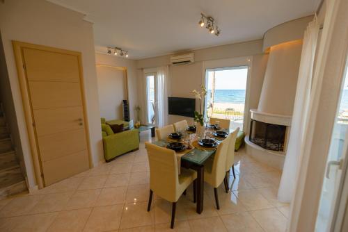 une salle à manger et un salon avec une table et des chaises dans l'établissement Lemoni Luxury Residence in front of the Sea, à Kekhriaí