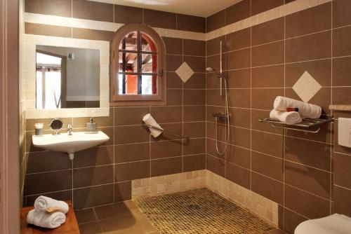 キュエールにあるl'Hotellerie Kourosのバスルーム(シャワー、シンク、鏡付)