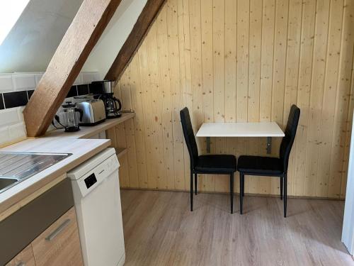 een kleine keuken met een tafel en 2 stoelen bij Exile on Mainstreet in Bad Bentheim Etage met uniek uitzicht! in Bad Bentheim