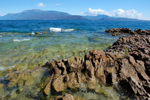 a view of the ocean with rocks in the water at Residence Boschetti in Manerba del Garda