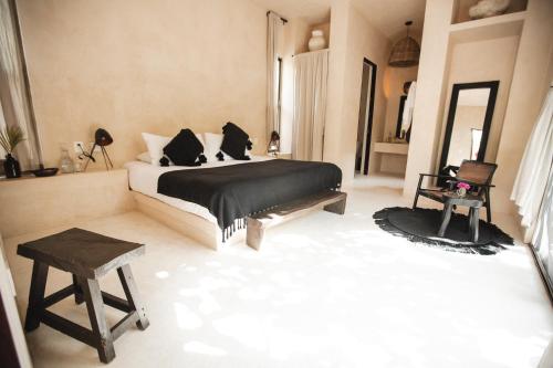 a bedroom with a bed and a stool in it at NEST Tulum in Tulum
