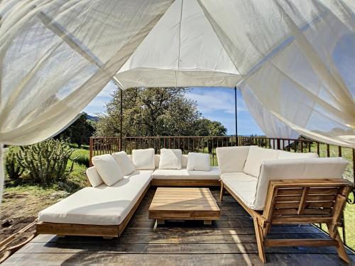 a group of white couches sitting on a patio at Domaine de Tappa - Casa Filicina in Sollacaro