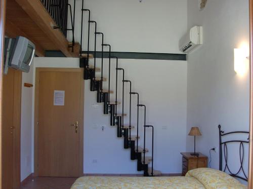 a spiral staircase in a living room with a bed at Agriturismo La Palazzina in Castelnuovo del Garda