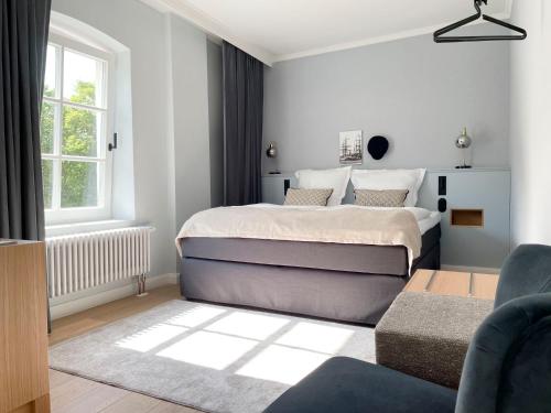 um quarto branco com uma cama e um sofá em Boutiquehotel Petuh em Flensburg