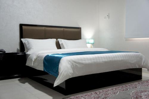 um quarto com uma cama grande e um cobertor azul em Valencia Hôtel & Appartements em Nouadhibou