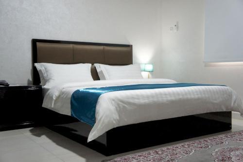 a bedroom with a large bed with a blue blanket at Valencia Hôtel & Appartements in Nouadhibou
