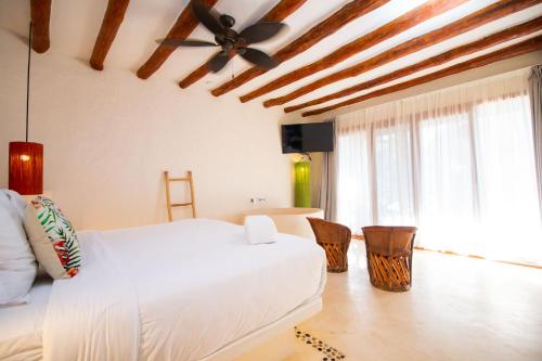 a bedroom with a white bed and a ceiling fan at Soho Boutique Holbox - Adults Only in Holbox Island