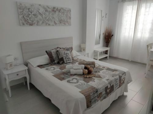 - une chambre blanche dotée d'un grand lit avec un ours en peluche dans l'établissement Almi Cabezo appartamento con terrazza El Médano, à El Médano