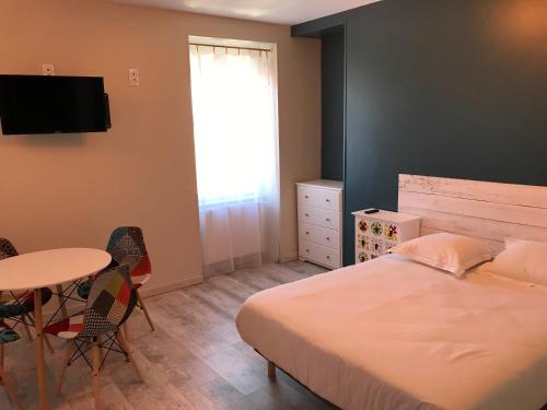 une chambre avec un lit, une table et une fenêtre dans l'établissement La Parenthèse de la Baie, à Courtils