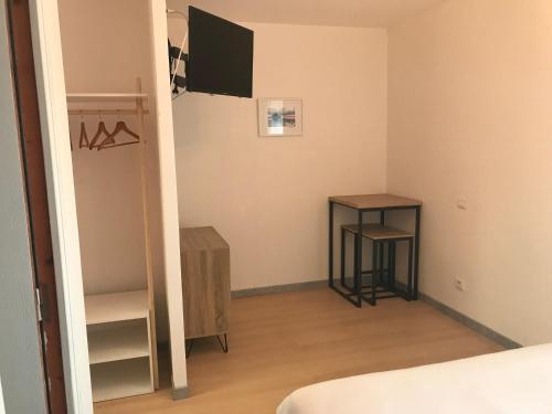 une chambre avec un lit, une table et un miroir dans l'établissement La Parenthèse de la Baie, à Courtils