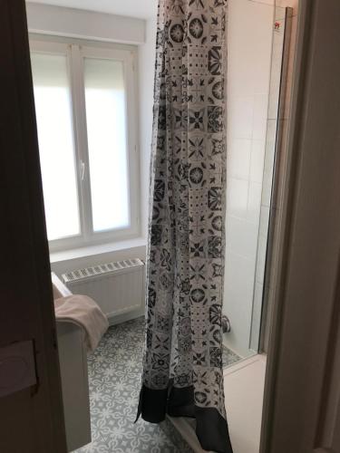 La salle de bains est pourvue d'un rideau de douche et d'une baignoire. dans l'établissement La Parenthèse de la Baie, à Courtils