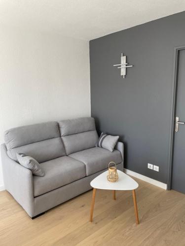 a living room with a couch and a table at Appartement T2 les minimes chic et cosy in La Rochelle