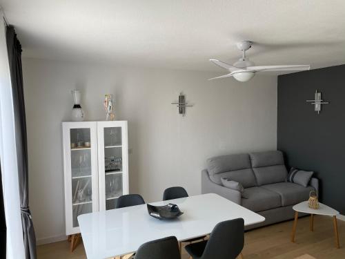a living room with a white table and a couch at Appartement T2 les minimes chic et cosy in La Rochelle
