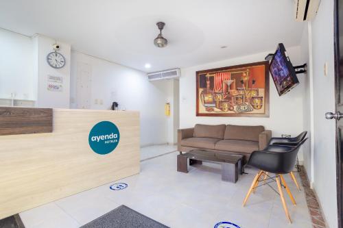 a waiting room with a couch and a table at Ayenda Hotel Alejandría in Montería