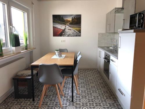a small kitchen with a wooden table and chairs at Big Ben's Guesthouse in Müllenbach