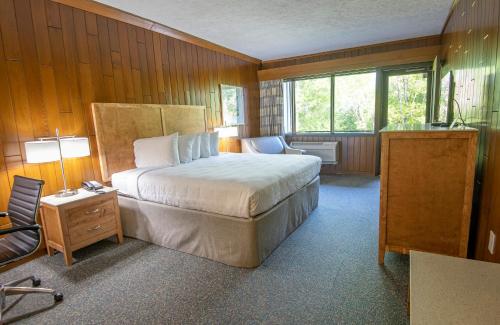 a bedroom with a bed and a chair in a room at Barren River Lake State Resort Park in Lucas