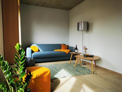 a living room with a blue couch and a table at Naturresort Bieleboh in Beiersdorf
