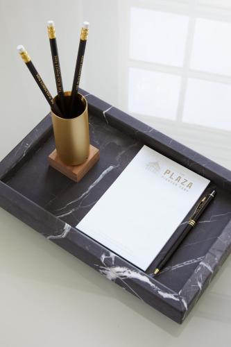 a black tray with a pen and a notebook on it at The Plaza Hotel Pioneer Park in El Paso
