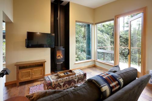 a living room with a couch and a tv at Middle Beach Lodge in Tofino