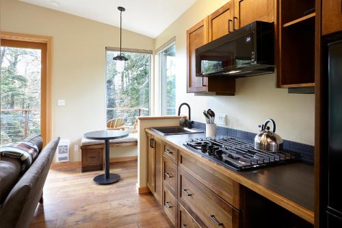 a kitchen with a stove top oven next to a couch at Middle Beach Lodge in Tofino