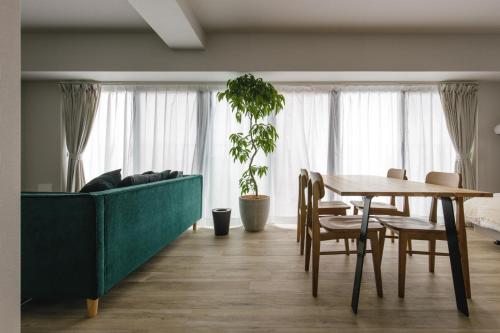 sala de estar con sofá verde y mesa en THREE - Vacation STAY 38687v, en Tokio