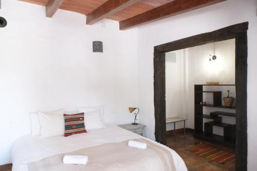 1 dormitorio con cama blanca y espejo en The Wild Olive Andalucía Agave Guestroom, en Casares