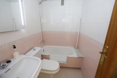ein Badezimmer mit einem Waschbecken, einem WC und einer Badewanne in der Unterkunft MARTA'S APARTMENT in Calafell
